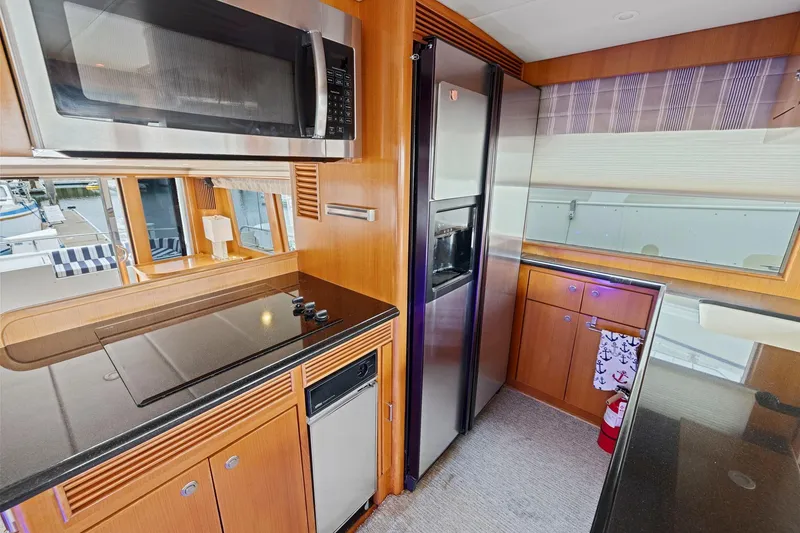 Slide: The Image of Modern yacht kitchen with stainless steel appliances, wood cabinetry, and large windows. Symbol 58, 2002. - 42