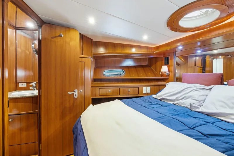Slide: The Image of Luxurious 2002 Symbol 58 yacht cabin with wood paneling and cozy bedding. - 51