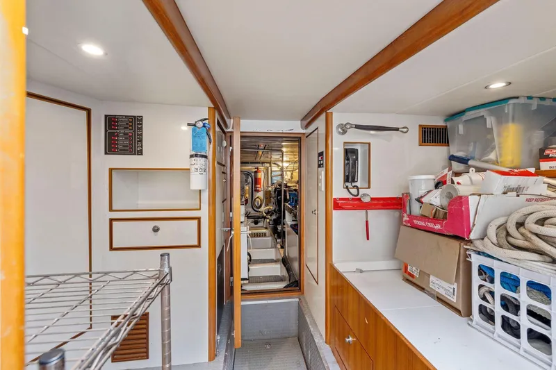 Slide: The Image of Engine room of a 2002 Symbol 58 yacht, featuring storage and equipment. - 54