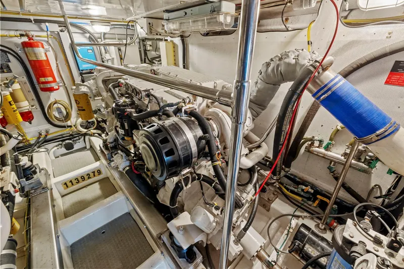 Slide: The Image of Engine room of a 2002 Symbol 58 yacht, featuring complex machinery and safety equipment. - 57
