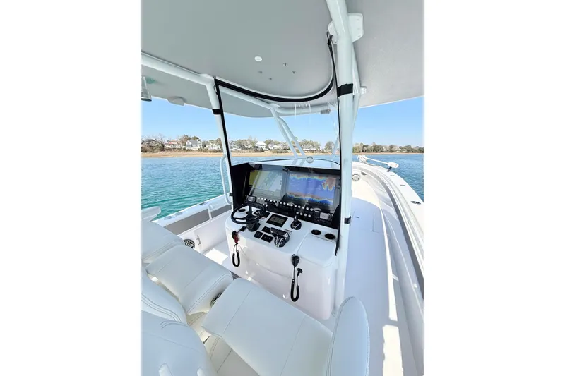 Slide: The Image of 2024 Contender 39 ST boat cockpit with advanced navigation system on calm waters. - 15