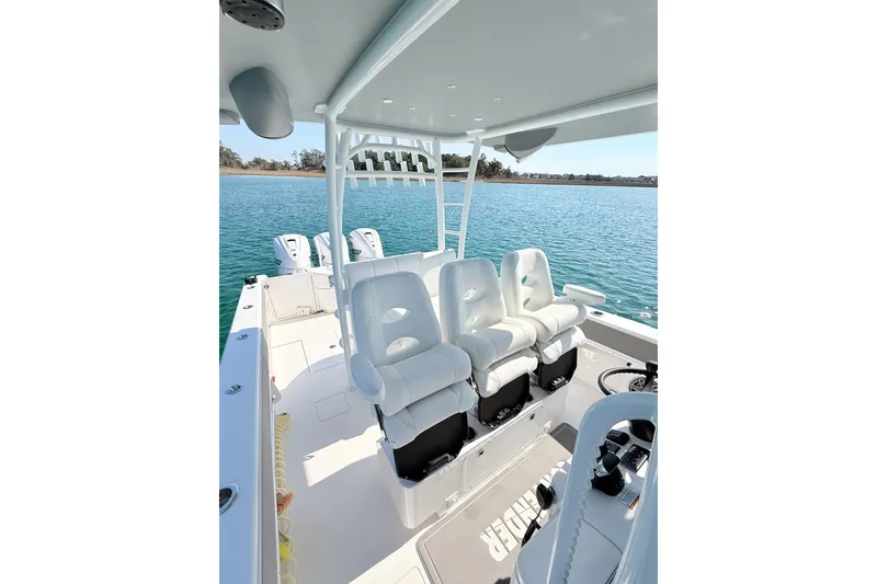 Slide: The Image of 2024 Contender 39 ST boat interior with white seating, ocean view in background. - 16