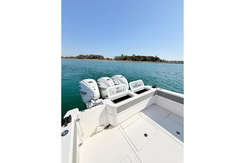 Slide: The Image of 2024 Contender 39 ST boat with triple outboard engines on calm water. - 19