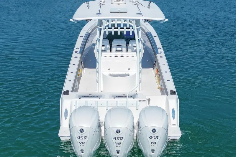Slide: The Image of 2024 Contender 39 ST boat with triple 450 V8 engines on clear blue water. - 3