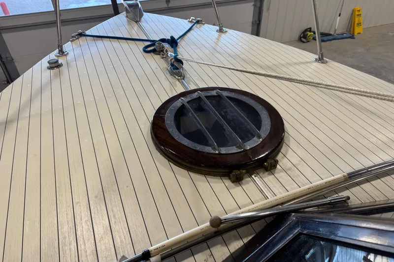 Slide: The Image of 1959 Chris-Craft 22 Sea Skiff deck with porthole and ropes in a garage. - 13