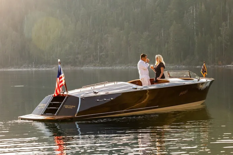 Slide: The Image of 2007 Hacker-Craft 32 Sportabout on serene lake with two people enjoying the view. - 1