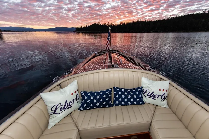 Slide: The Image of 2007 Hacker-Craft 32 Sportabout boat at sunset with patriotic pillows and serene lake view. - 10