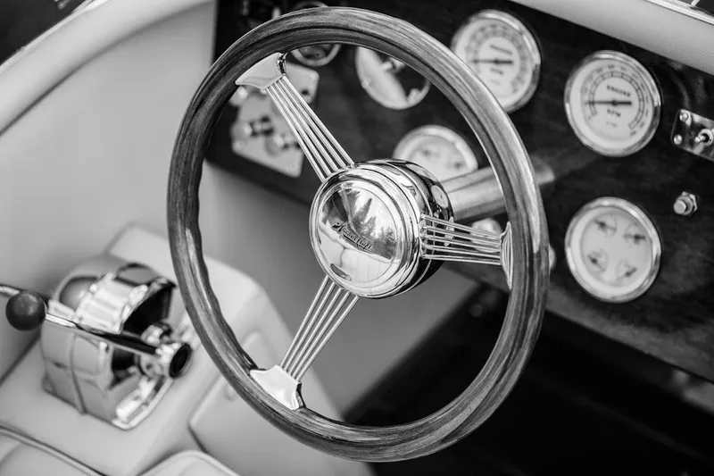 Slide: The Image of Steering wheel and dashboard of 2007 Hacker-Craft 32 Sportabout boat, featuring classic gauges. - 14