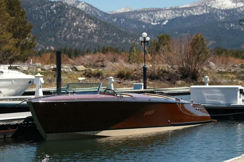 Slide: The Image of 2007 Hacker-Craft 32 Sportabout boat docked with mountain backdrop. - 16