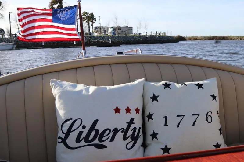 Slide: The Image of 2007 Hacker-Craft 32 Sportabout with patriotic pillows and American flag on a sunny day. - 18