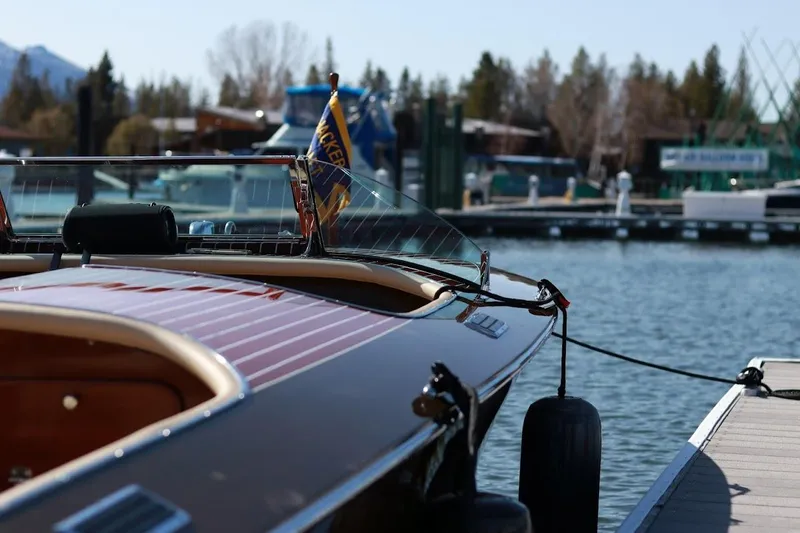 Slide: The Image of 2007 Hacker-Craft 32 Sportabout boat docked at a marina, showcasing elegant wooden design. - 20