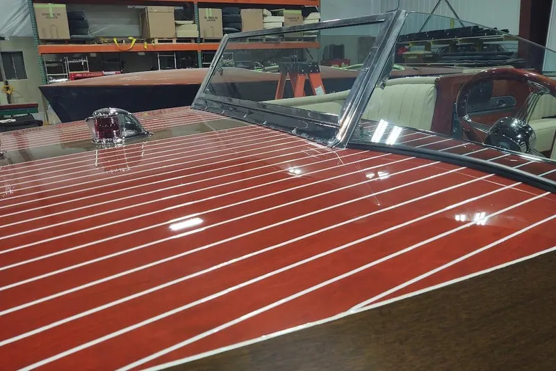 Slide: The Image of 2007 Hacker-Craft 32 Sportabout with polished wood finish and chrome details in a workshop. - 21