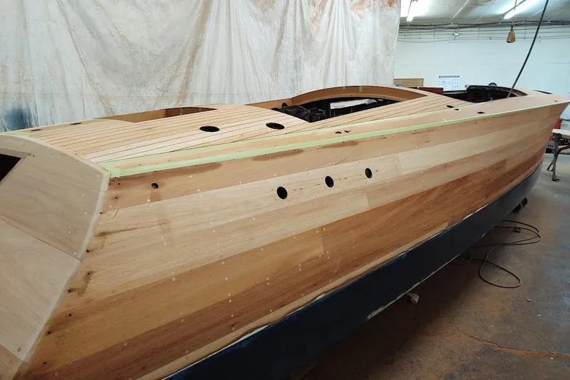 Slide: The Image of 2007 Hacker-Craft 32 Sportabout wooden boat under construction in a workshop. - 32