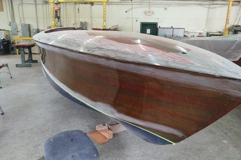 Slide: The Image of 2007 Hacker-Craft 32 Sportabout boat in workshop, showcasing wooden hull and classic design. - 34