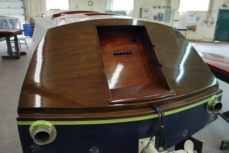 Slide: The Image of 2007 Hacker-Craft 32 Sportabout boat in workshop, showcasing polished wooden stern. - 36