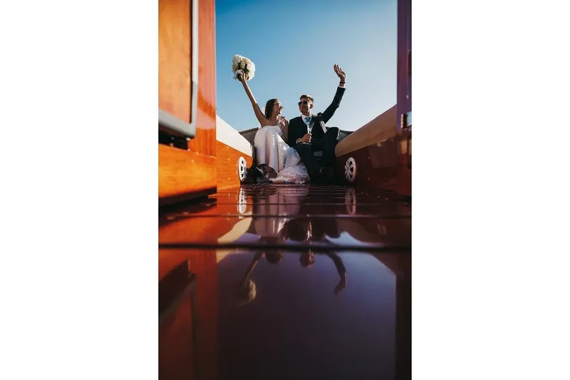 Slide: The Image of Couple celebrating on 2007 Hacker-Craft 32 Sportabout boat under clear blue sky. - 38