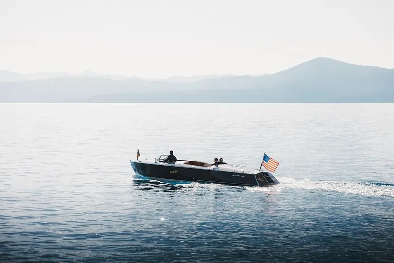 Slide: The Image of 2007 Hacker-Craft 32 Sportabout cruising on a serene lake with mountains in the background. - 39