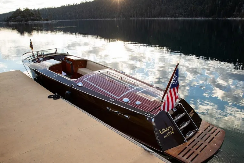 Slide: The Image of 2007 Hacker-Craft 32 Sportabout boat docked on a serene lake at sunset. - 7