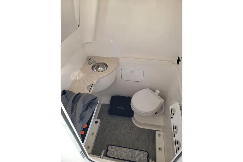 Slide: The Image of 2022 Regulator 31 boat interior with compact bathroom, sink, and toilet. - 11