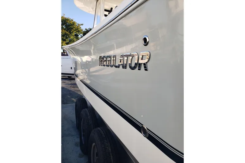 Slide: The Image of 2022 Regulator 31 boat side view with logo, parked on a trailer. - 19