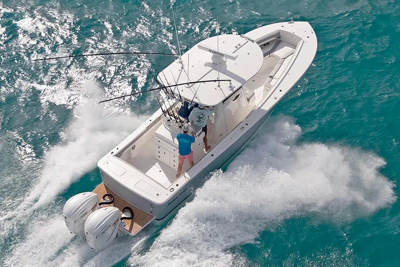 Slide: The Image of 2022 Regulator 31 boat cruising on clear blue water, equipped with dual outboard engines. - 2