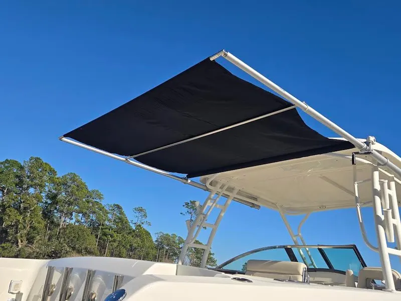 Slide: The Image of 2018 Boston Whaler 270 Vantage with sunshade against blue sky. - 5