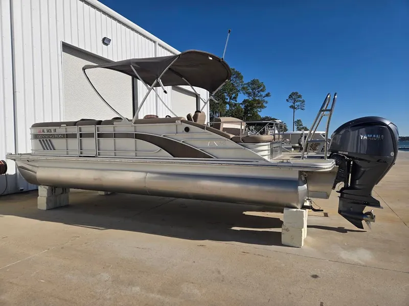 The Image of 2021 Bennington LX24SBSD pontoon boat with Yamaha motor, parked on concrete blocks. - 0