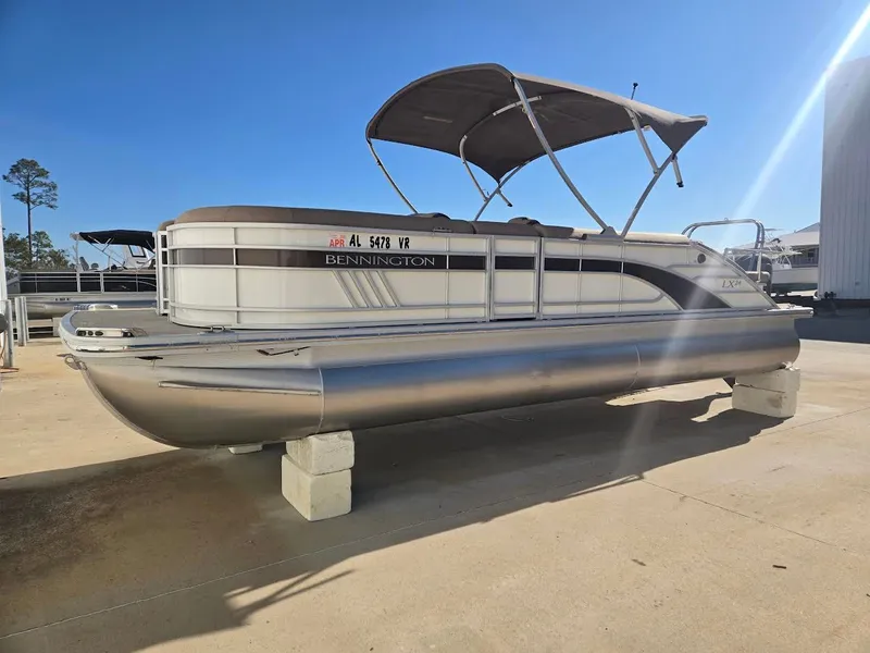 Slide: The Image of 2021 Bennington LX24SBSD pontoon boat on concrete blocks outdoors. - 3