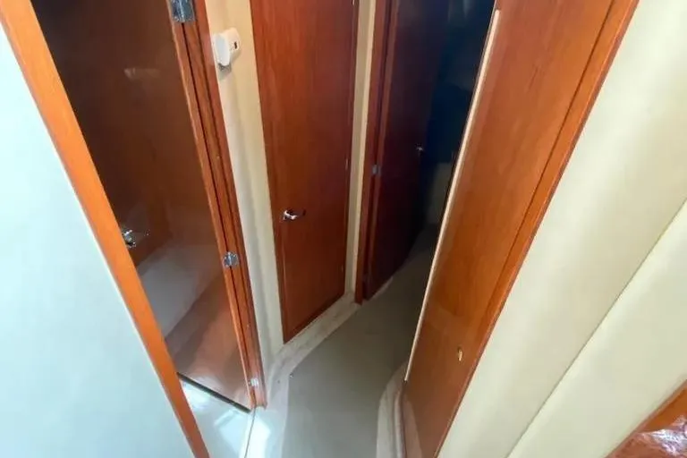 Slide: The Image of Interior hallway of 2000 Sea Ray 400 Sedan Bridge with wooden doors. - 15