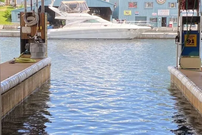 Slide: The Image of 2000 Sea Ray 400 Sedan Bridge yacht docked at marina with blue building background. - 4