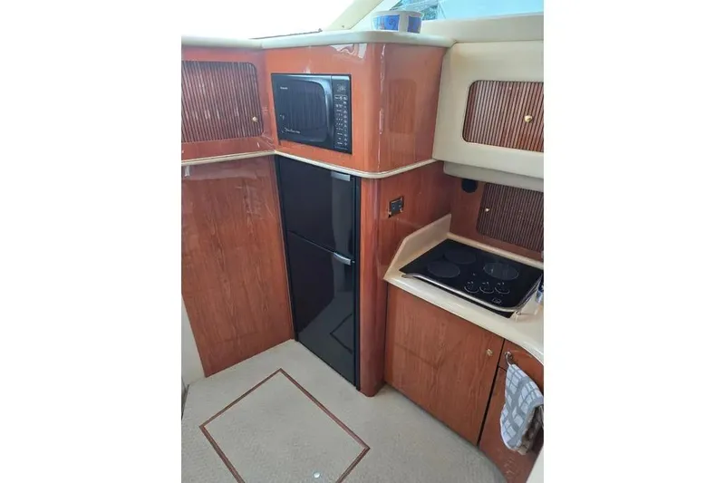 Slide: The Image of Interior of 2000 Sea Ray 400 Sedan Bridge yacht kitchen with wood cabinetry. - 5