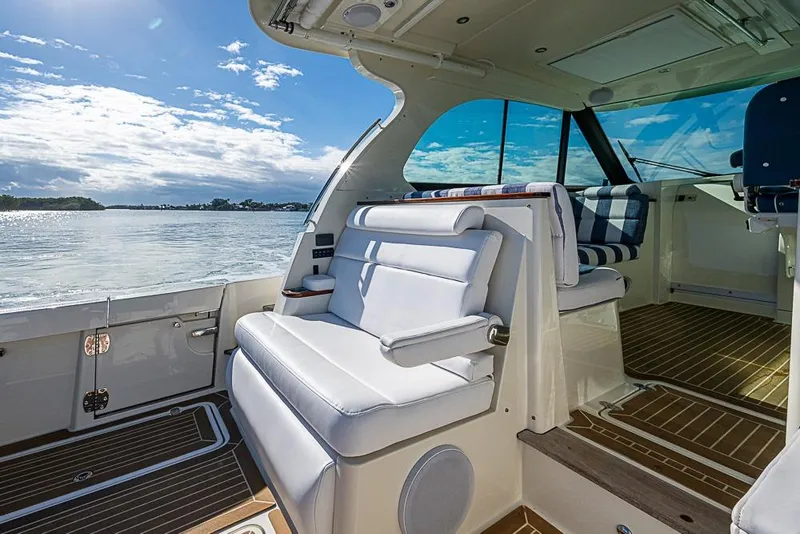 Slide: The Image of 2023 Hinckley Sport Boat 40 X interior with white seating and scenic water view. - 11