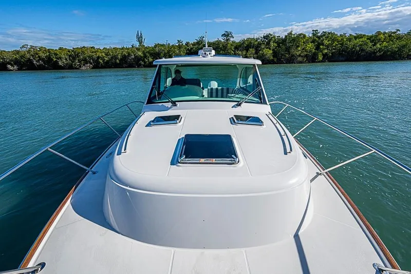 Slide: The Image of 2023 Hinckley Sport Boat 40 X cruising on a serene waterway. - 36