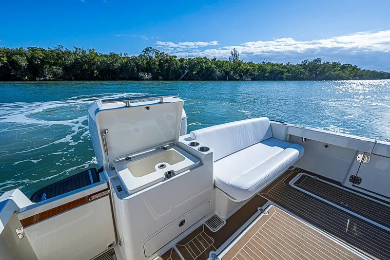 Slide: The Image of 2023 Hinckley Sport Boat 40 X, featuring a sleek deck and comfortable seating by the water. - 9