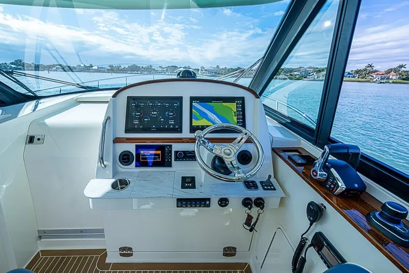 Slide: The Image of 2023 Hinckley Sport Boat 40 X helm with advanced navigation system and scenic water view. - 19