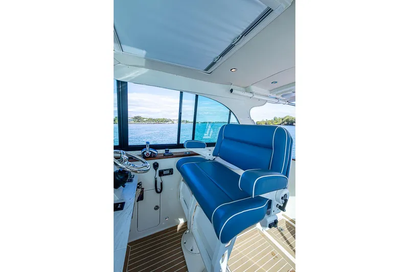Slide: The Image of Interior of 2023 Hinckley Sport Boat 40 X with blue seating and scenic water view. - 20