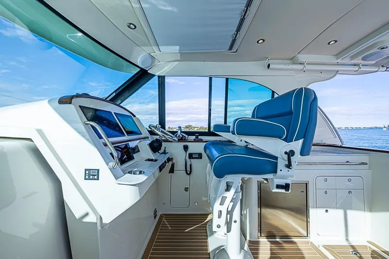 Slide: The Image of 2023 Hinckley Sport Boat 40 X cockpit with modern controls and blue captain's chair. - 21