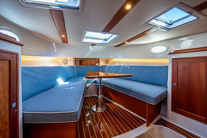 Slide: The Image of Luxurious interior of 2023 Hinckley Sport Boat 40 X with blue seating and wooden accents. - 27