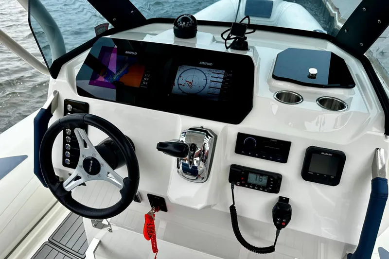 Slide: The Image of 2022 Brig Eagle 8 boat dashboard with steering wheel, navigation screens, and controls. - 12