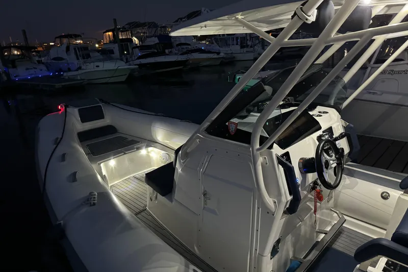 Slide: The Image of 2022 Brig Eagle 8 boat interior illuminated at night in a marina setting. - 18