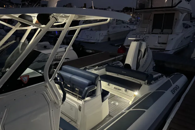 Slide: The Image of 2022 Brig Eagle 8 boat docked at night, illuminated interior, luxury seating. - 19