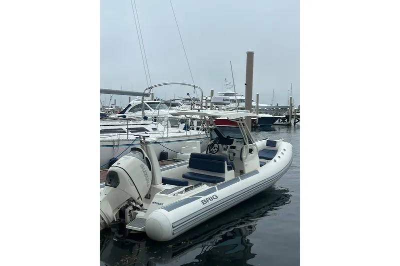 Slide: The Image of 2022 Brig Eagle 8 boat docked in a marina, featuring a sleek design and modern outboard motor. - 2