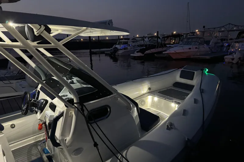 Slide: The Image of 2022 Brig Eagle 8 boat illuminated at night in a marina setting. - 20