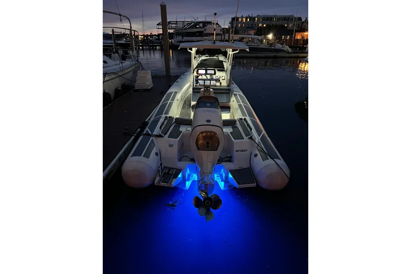 Slide: The Image of 2022 Brig Eagle 8 boat docked at night with blue underwater lights. - 22