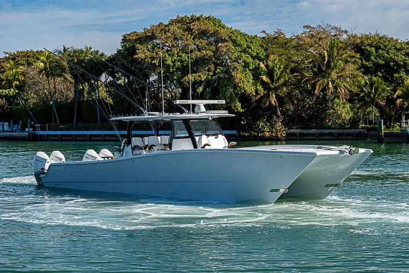 Slide: The Image of 2023 Freeman 47 boat cruising on a scenic waterway with lush greenery. - 1