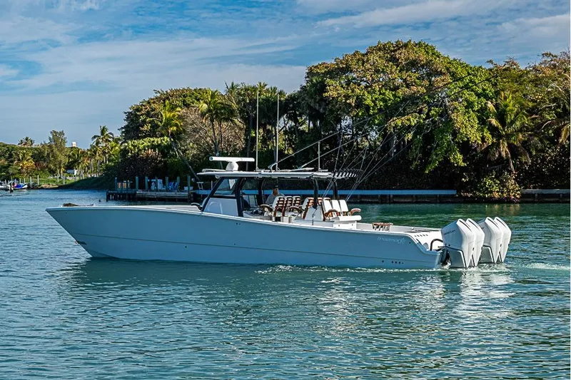 Slide: The Image of 2023 Freeman 47 boat cruising on a serene waterway with lush greenery. - 13