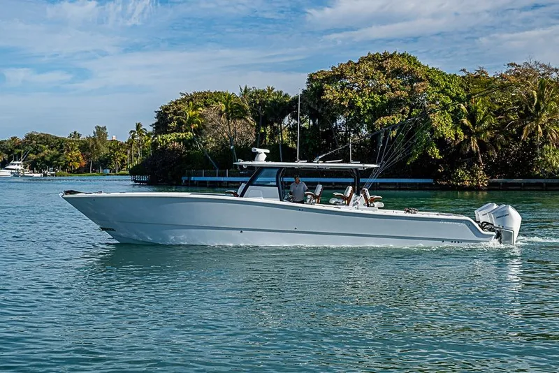 Slide: The Image of 2023 Freeman 47 boat cruising on a scenic waterway with lush greenery. - 15