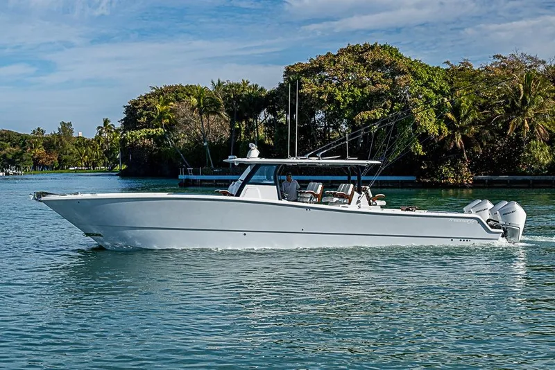 Slide: The Image of 2023 Freeman 47 boat cruising on a serene waterway with lush greenery. - 16