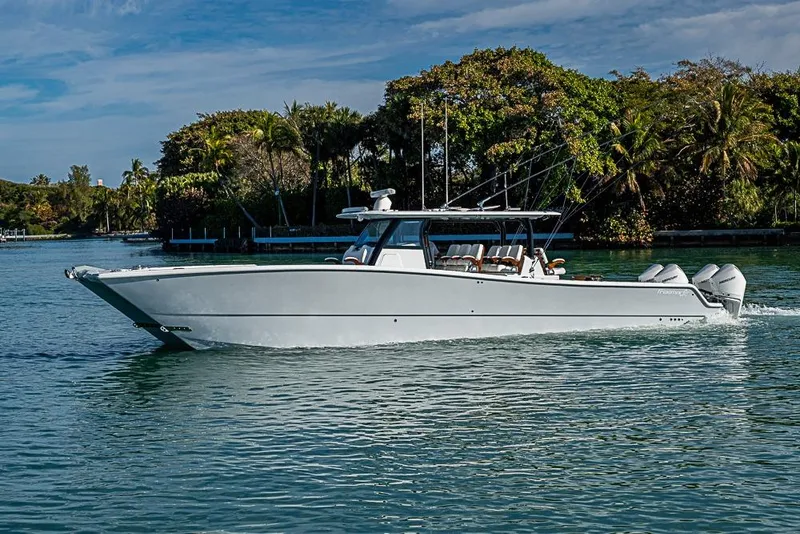 Slide: The Image of 2023 Freeman 47 boat cruising on a serene waterway with lush greenery. - 17