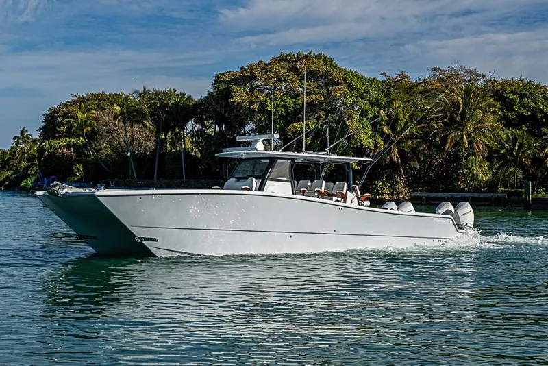 Slide: The Image of 2023 Freeman 47 boat cruising on a scenic waterway with lush greenery. - 18